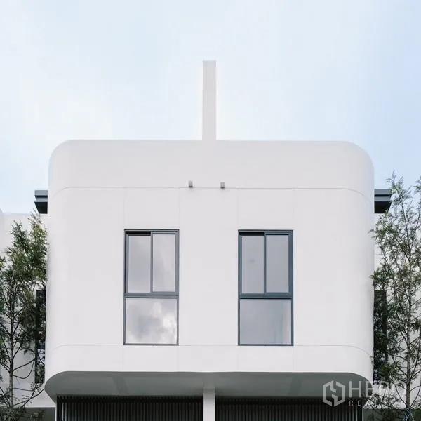 Townhouse for sale in Phra Khanong, Bangkok - Front elevation close-up with two tall windows and crisp contemporary lines.