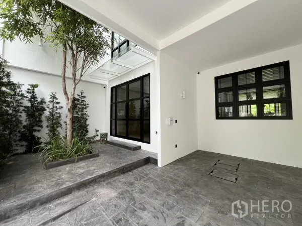 ทาวน์เฮาส์ ขายในWatthana, Bangkok - โรงจอดรถเชื่อมต่อคอร์ทยาร์ด พร้อมบันไดและหน้าต่างกรอบดำบานใหญ่