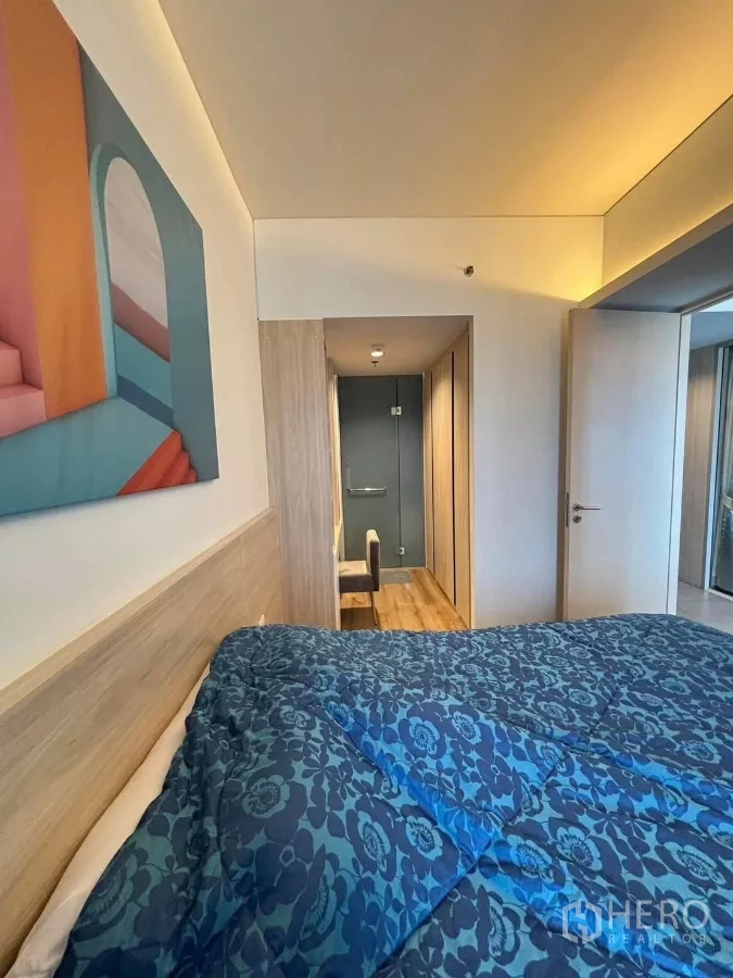Condominium for rent or sale in Phaya Thai, Bangkok - Bedroom view toward corridor and entry, showing warm lighting and wood flooring.