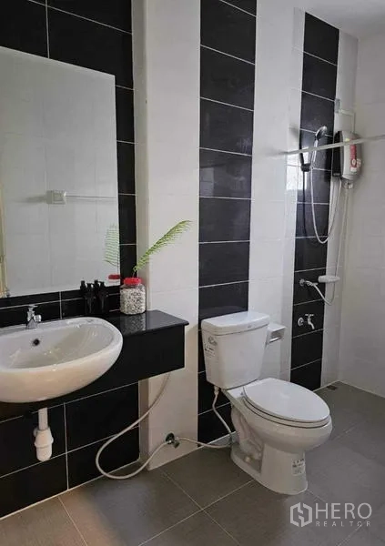 Detached House for rent in Lam Luk Ka, Pathum Thani - Black-and-white tiled bathroom with shower, toilet and vanity mirror.