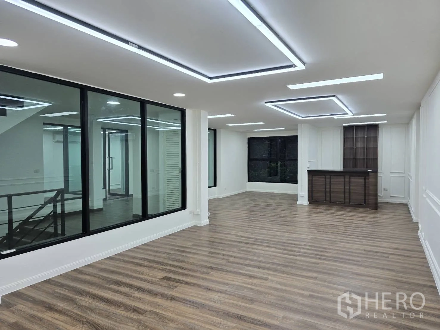 Home Office for rent in Chatuchak, Bangkok - Spacious open-plan office with LED lighting, large windows and built-in wood cabinetry.