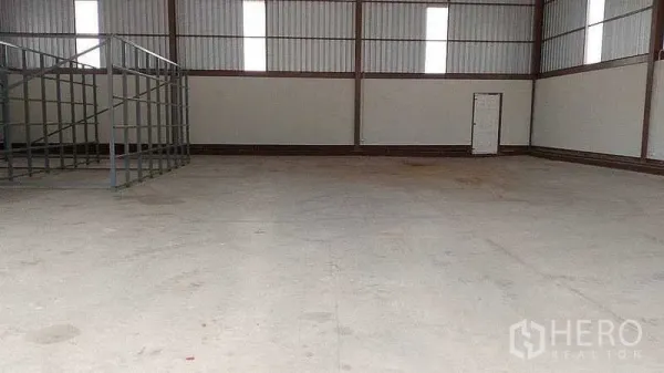 Warehouse for rent or sale in Nakhon Pathom - Spacious warehouse interior with high clear-span ceiling, steel frames and smooth concrete floor.
