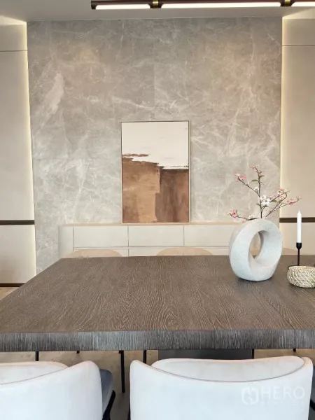 Detached House for rent in Saphan Sung, Bangkok - Close-up of a modern dining table with a sculptural vase against a stone-textured feature wall.