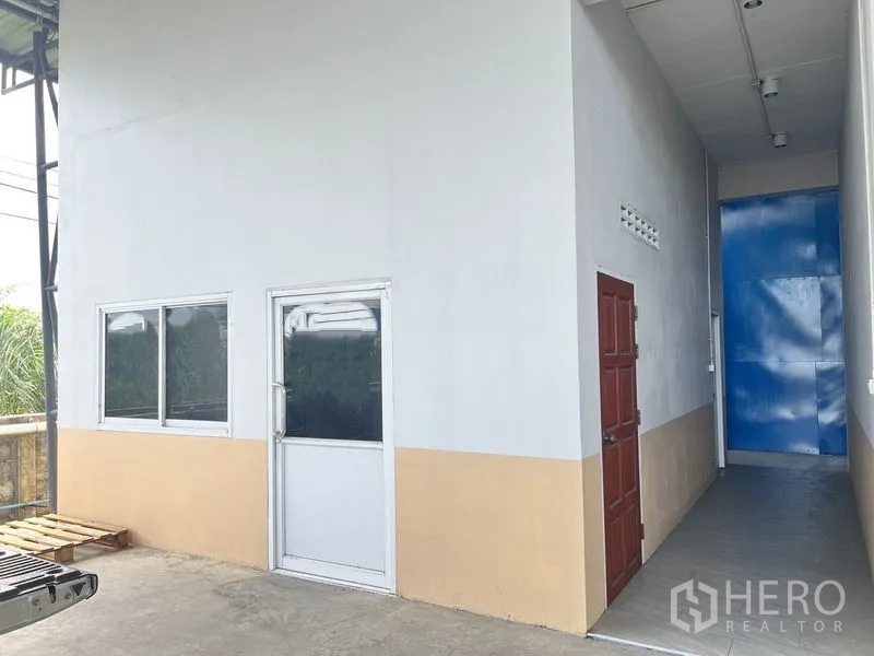货栈 出租在Lat Krabang, Bangkok - 办公室旁服务走廊，外部门与米色拼白色墙面。