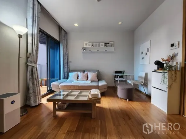 Condominium for rent in Watthana, Bangkok - Airy lounge with floor lamp, wide curtains and access to a private balcony.