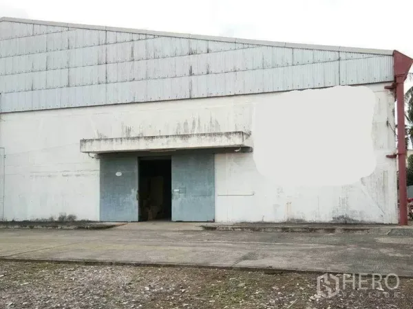 Warehouse for rent in Khlong Toei, Bangkok - Front exterior of an industrial warehouse with large metal sliding doors and a concrete loading apron.