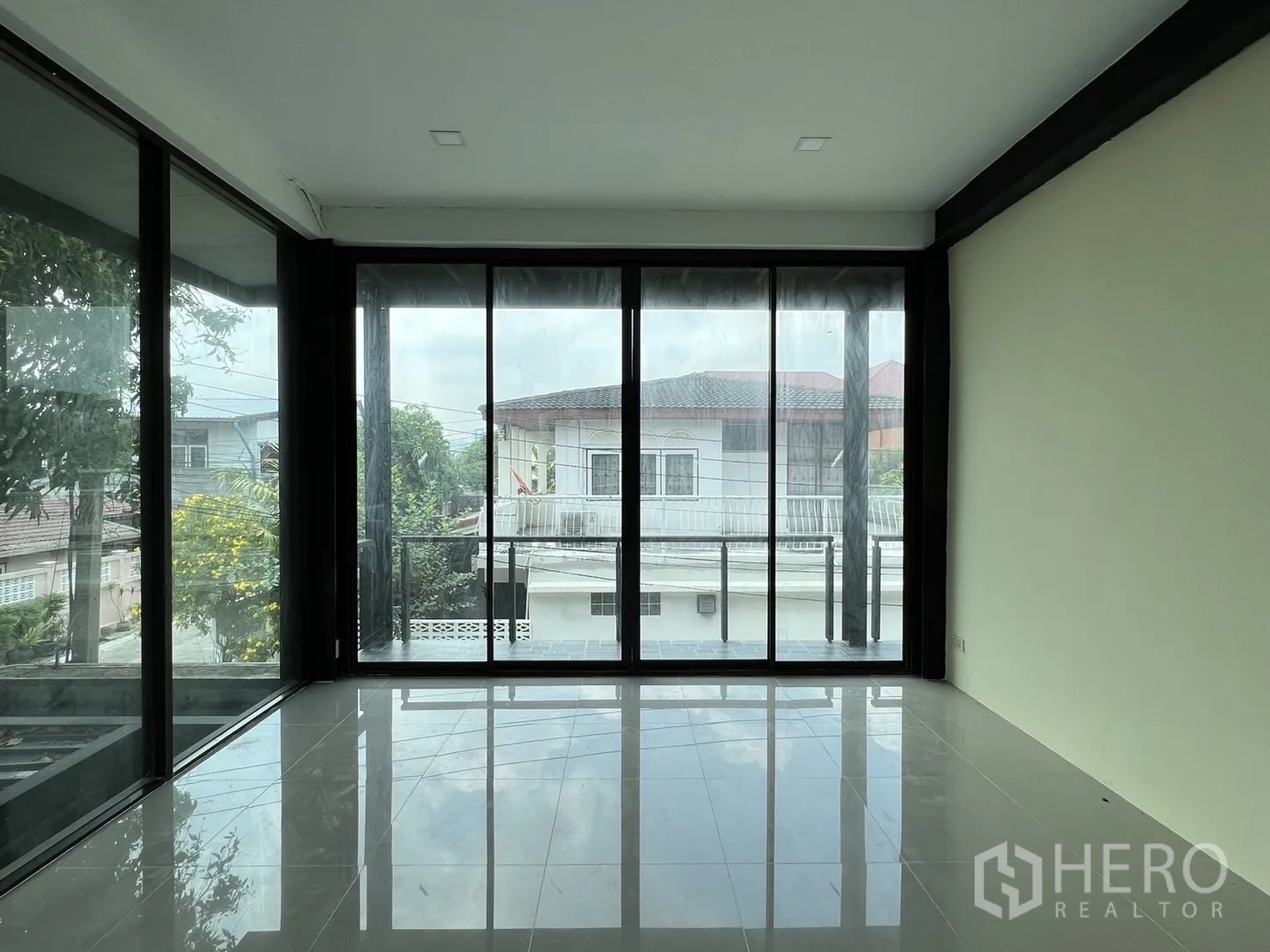 Detached House for rent or sale in Phra Khanong, Bangkok - Bedroom with sliding glass door to balcony and neighborhood view.