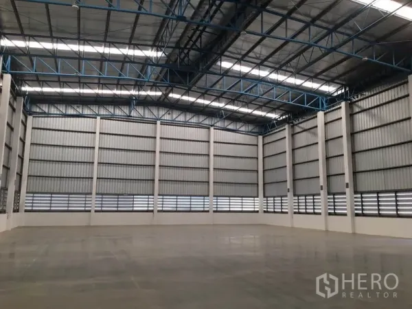 Warehouse for rent in Lat Krabang, Bangkok - Spacious warehouse interior with high steel truss roof, ventilated wall panels, and polished concrete floor.