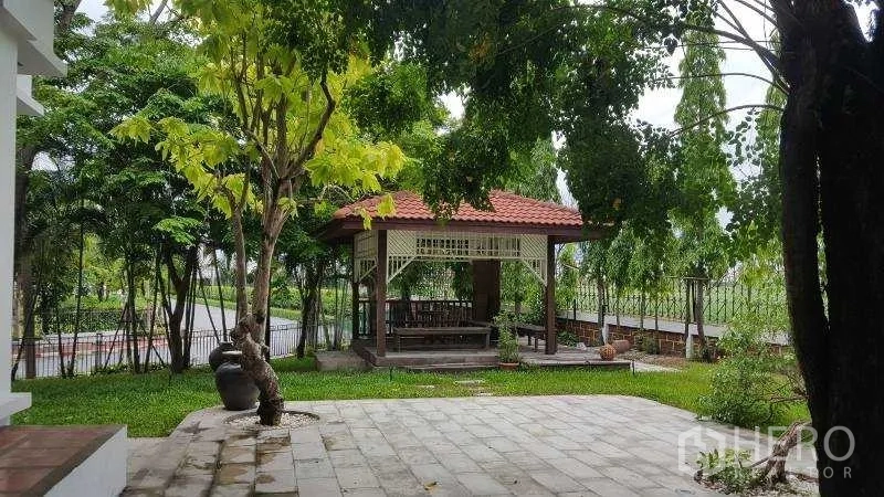 独立式住宅 出租在Bang Phli, Samut Prakan - 花园露台树荫浓密，设有凉亭与草坪景观。