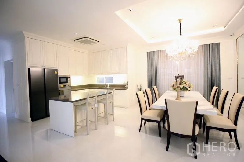 Detached House for rent or sale - Western kitchen with L-shaped counters and island breakfast bar beside a formal dining table and chandelier.