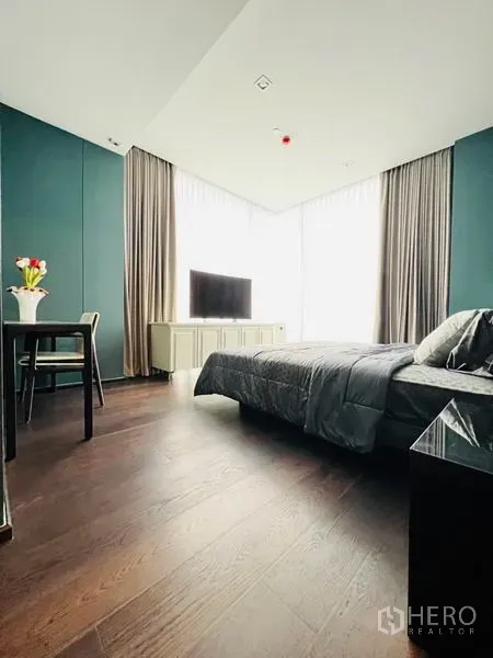 คอนโด ให้เช่าในWatthana, Bangkok - มุมห้องนอนใหญ่โชว์หน้าต่างมุมสูงพร้อมม่านโปร่งและชั้นวางทีวี