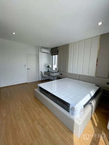 Townhouse for rent in Bang Phli, Samut Prakan - Open-plan living room facing balcony with sheer curtains and TV wall.