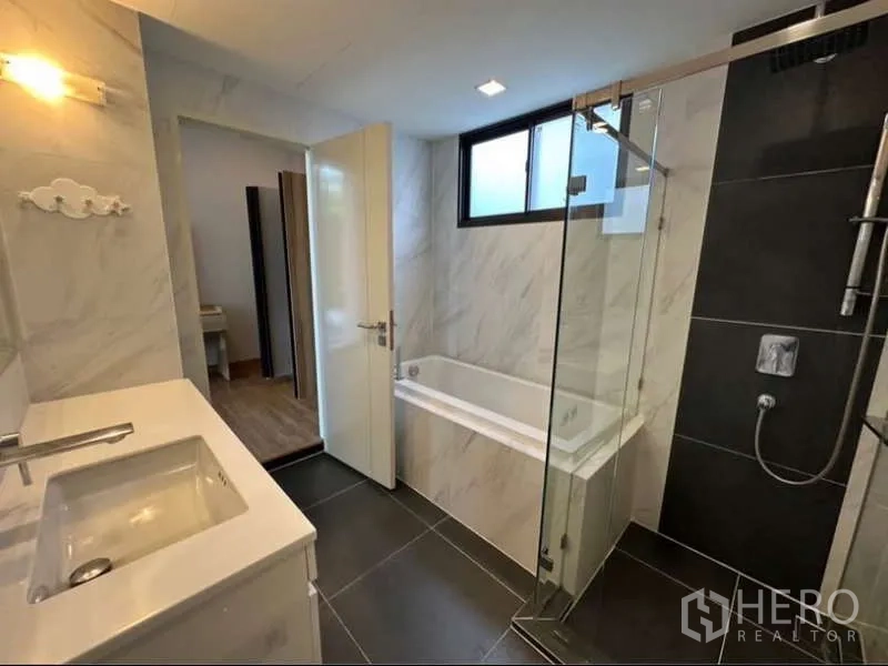 Townhouse for rent in Lat Phrao, Bangkok - Stylish bathroom with separate glass shower and built-in bathtub.