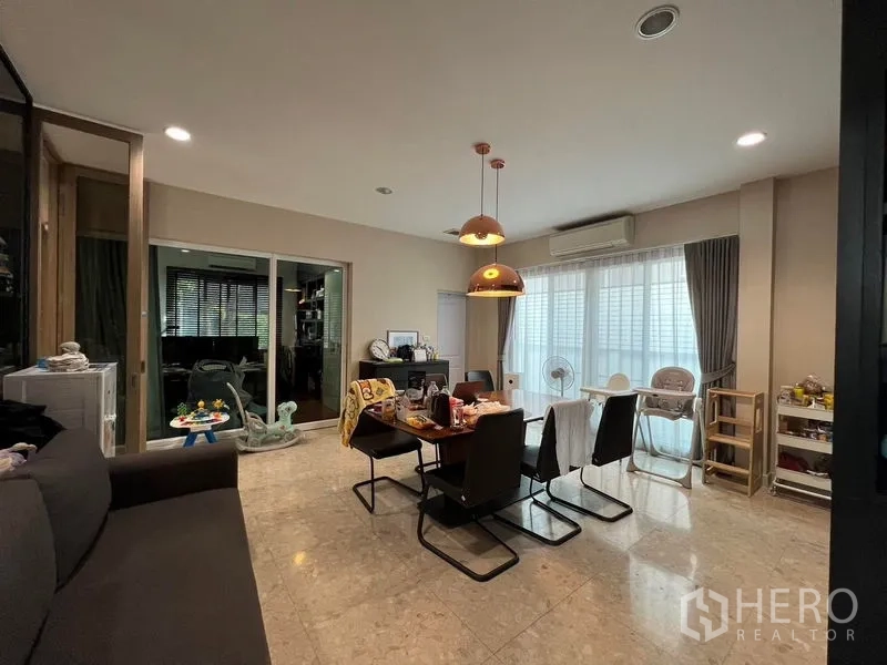 Detached House for rent or sale in Saphan Sung, Bangkok - Dining area with pendant lights, large windows and air conditioning.