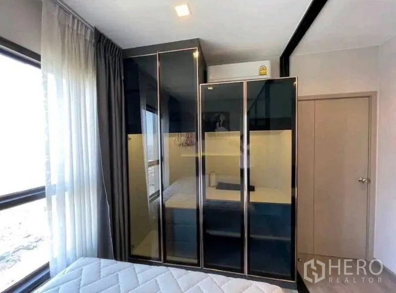 公寓 出租在Yan Nawa, Bangkok - 卧室一角，落地窗与高光内置衣柜。