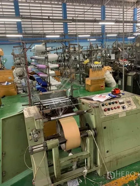 Warehouse for sale in Mueang Samut Sakhon, Samut Sakhon - Control panel and spooling equipment used for fabric production in the factory zone.