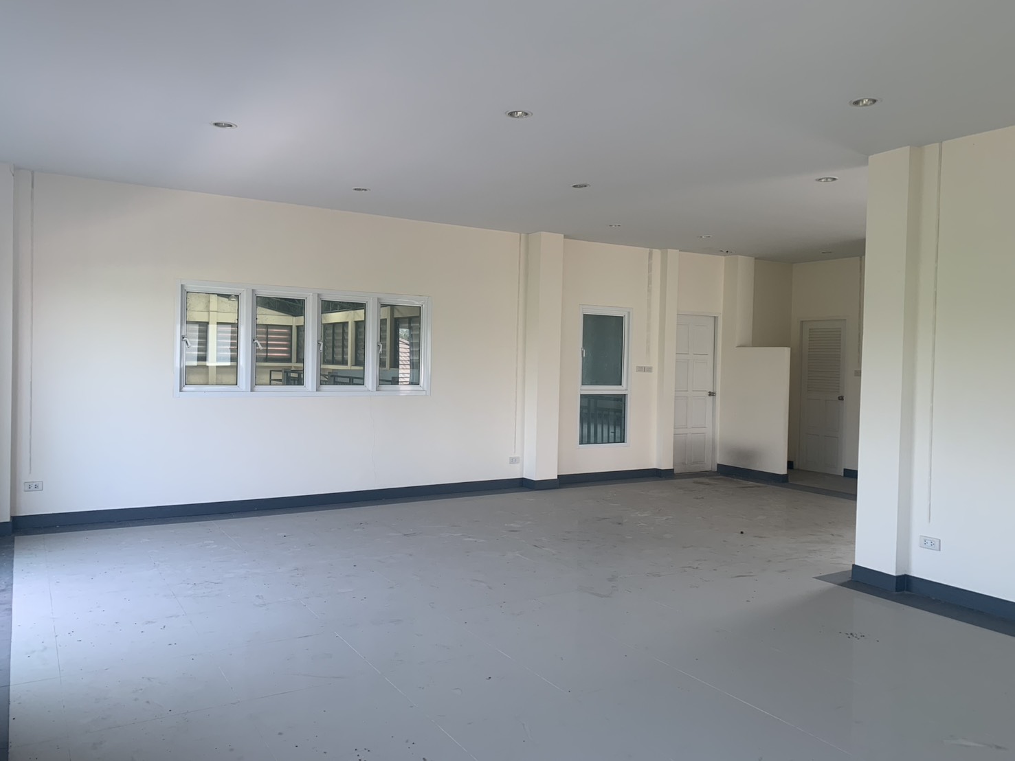 Warehouse for rent in Lam Luk Ka, Pathum Thani - Another spacious upper-level office with a windowed wall and white doors.