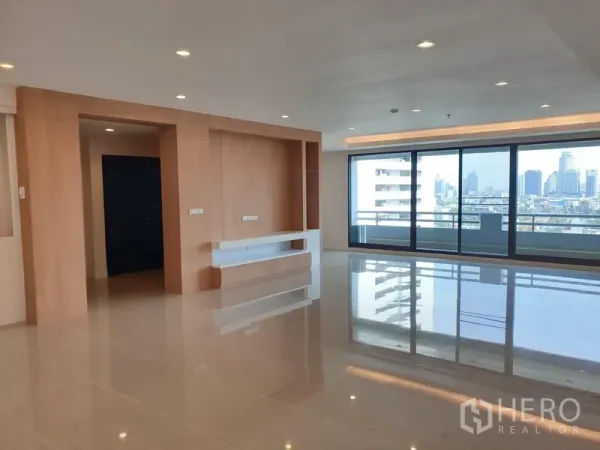 คอนโด ให้เช่าในWatthana, Bangkok - ห้องนั่งเล่นกว้างปูพื้นเงา มีผนังบิลท์อินและประตูกระจกเต็มบานออกสู่ระเบียง ชมวิวสกายไลน์เมือง