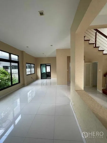 独立式住宅 出售在Lat Krabang, Bangkok - 开放式客餐厅，面向花园的窗户与楼梯相连。