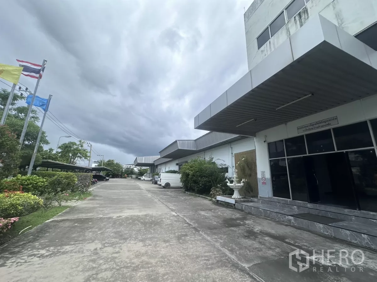 工厂 出售在Lat Krabang, Bangkok - 外部车道，绿化花园与旗杆，临近办公楼。