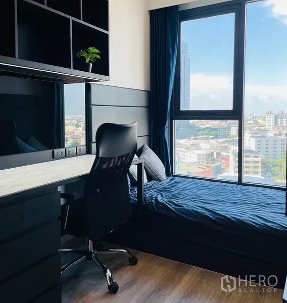 Condominium for rent in Bang Na, Bangkok - Second bedroom with built-in desk, shelving and a single bed facing the skyline.
