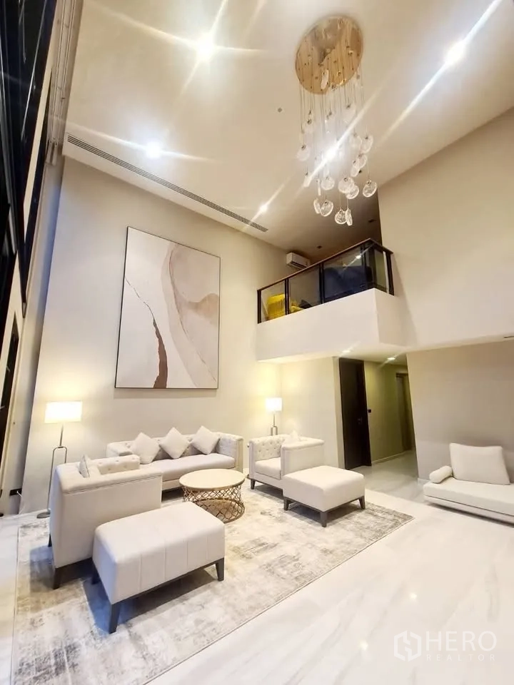 ทาวน์เฮาส์ for rent or sale in Watthana, Bangkok - ห้องนั่งเล่นเพดานสูงติดแชนเดอเลียร์ พร้อมโซฟาและชั้นลอยด้านบน
