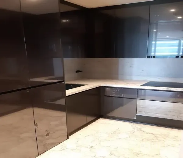 公寓 出租在Watthana, Bangkok - U形现代厨房，亮面柜体、石材台面与电磁炉。