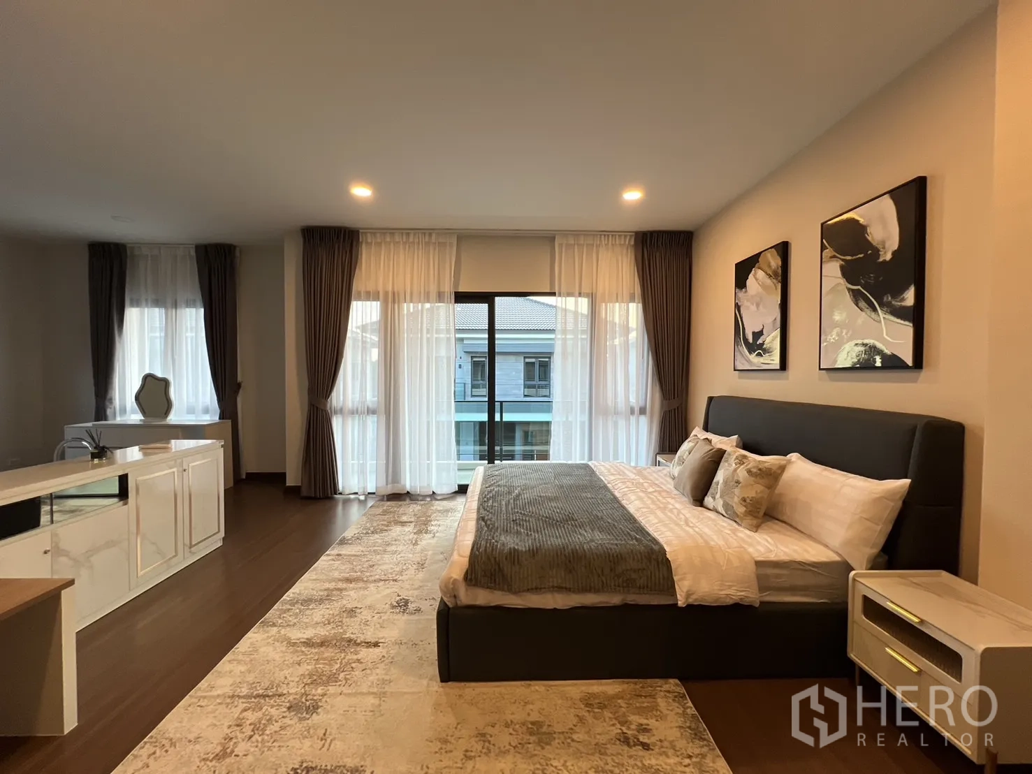 Detached House for rent or sale in Bang Phli, Samut Prakan - Master bedroom suite with king bed, balcony doors and seating area.