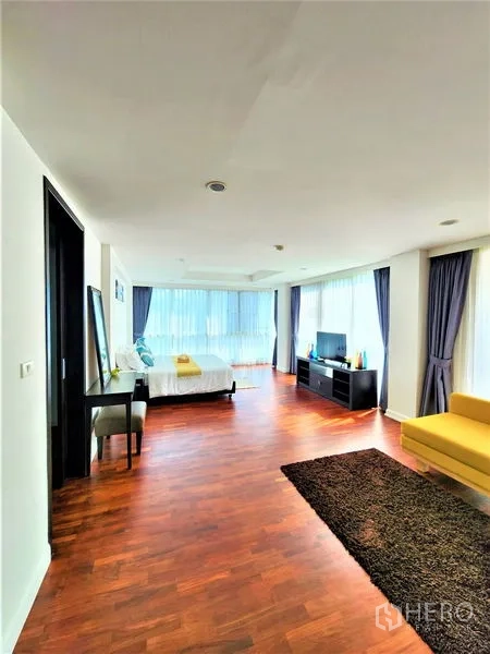Condominium for rent in Bang Rak, Bangkok - Expansive master suite with seating area, TV console, and wraparound windows.