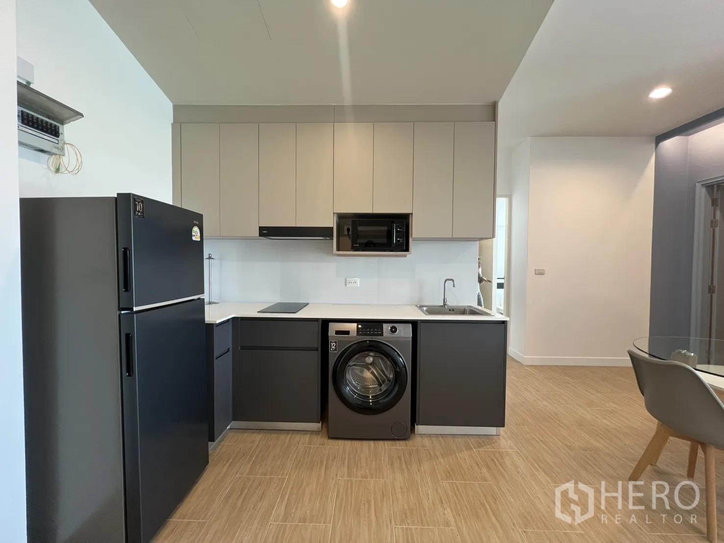公寓 for rent in Bang Kapi, Bangkok - 现代L型厨房，配有哑光橱柜、冰箱、洗衣机、微波炉和水槽。