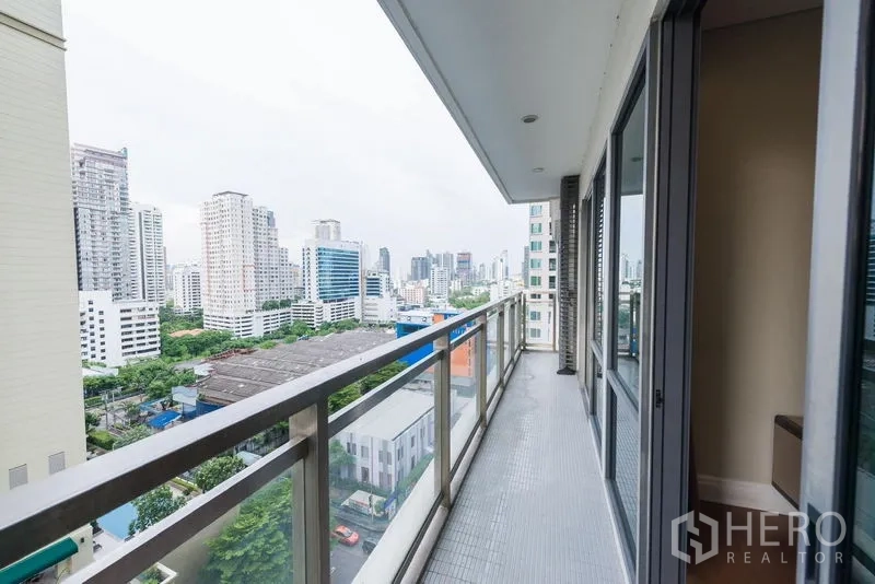 Condominium for rent in Khlong Toei, Bangkok - Long balcony with glass railing overlooking Sukhumvit high-rises and greenery.