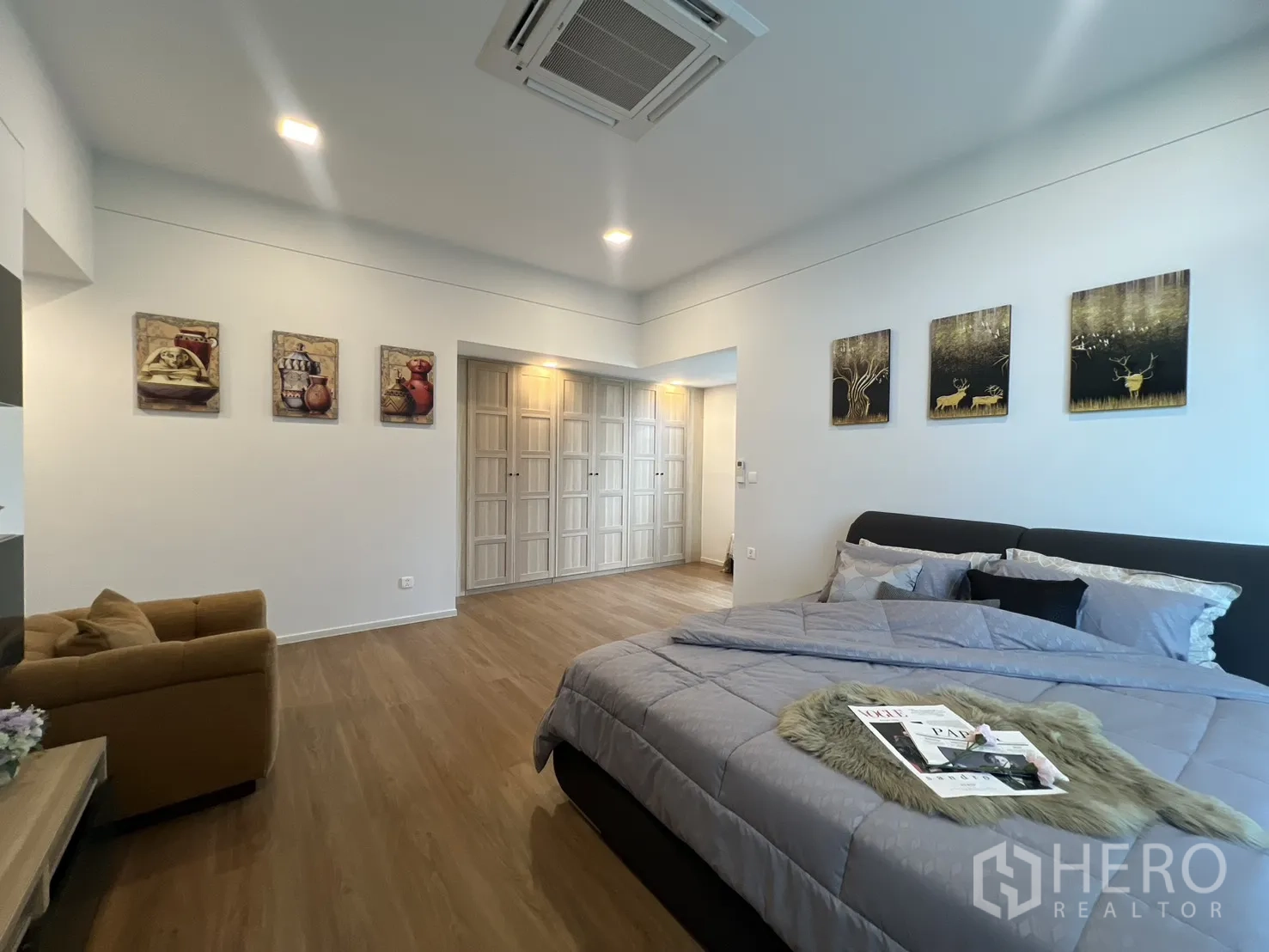Detached House for rent in Saphan Sung, Bangkok - Master suite with bed, display shelving and warm lighting.