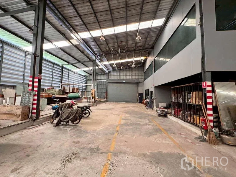 Warehouse for rent in Prawet, Bangkok - Loading zone inside the warehouse with roller shutter and marked lanes.