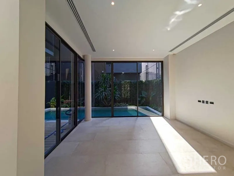 Detached House for rent in Wang Thonglang, Bangkok - Sunlit multipurpose room with glass walls and views of the pool.