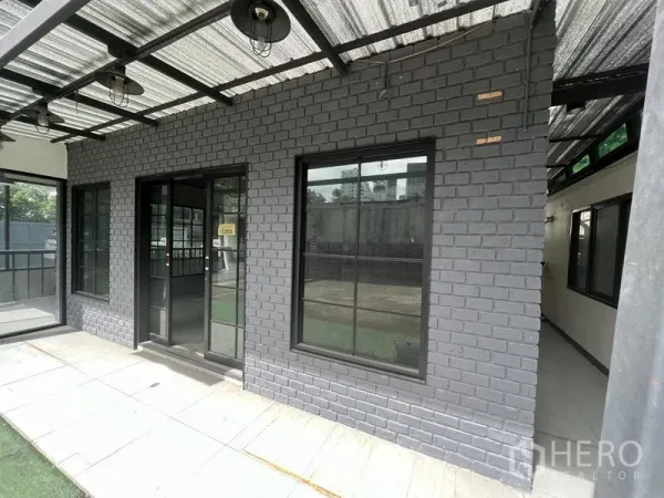Retail Space for rent in Watthana, Bangkok - Gray brick storefront with black-framed windows and double glass doors under a canopy.