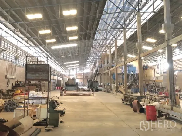 Factory for rent in Bang Bua Thong, Nonthaburi - Large factory interior with bright lighting, machinery lines, and open work space.