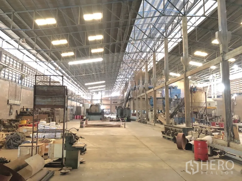 Factory for rent in Bang Bua Thong, Nonthaburi - Large factory interior with bright lighting, machinery lines, and open work space.