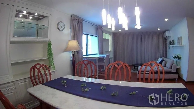 Condominium for rent or sale in Din Daeng, Bangkok - Dining zone with display cabinet, hanging lights and a view toward the cozy living area.