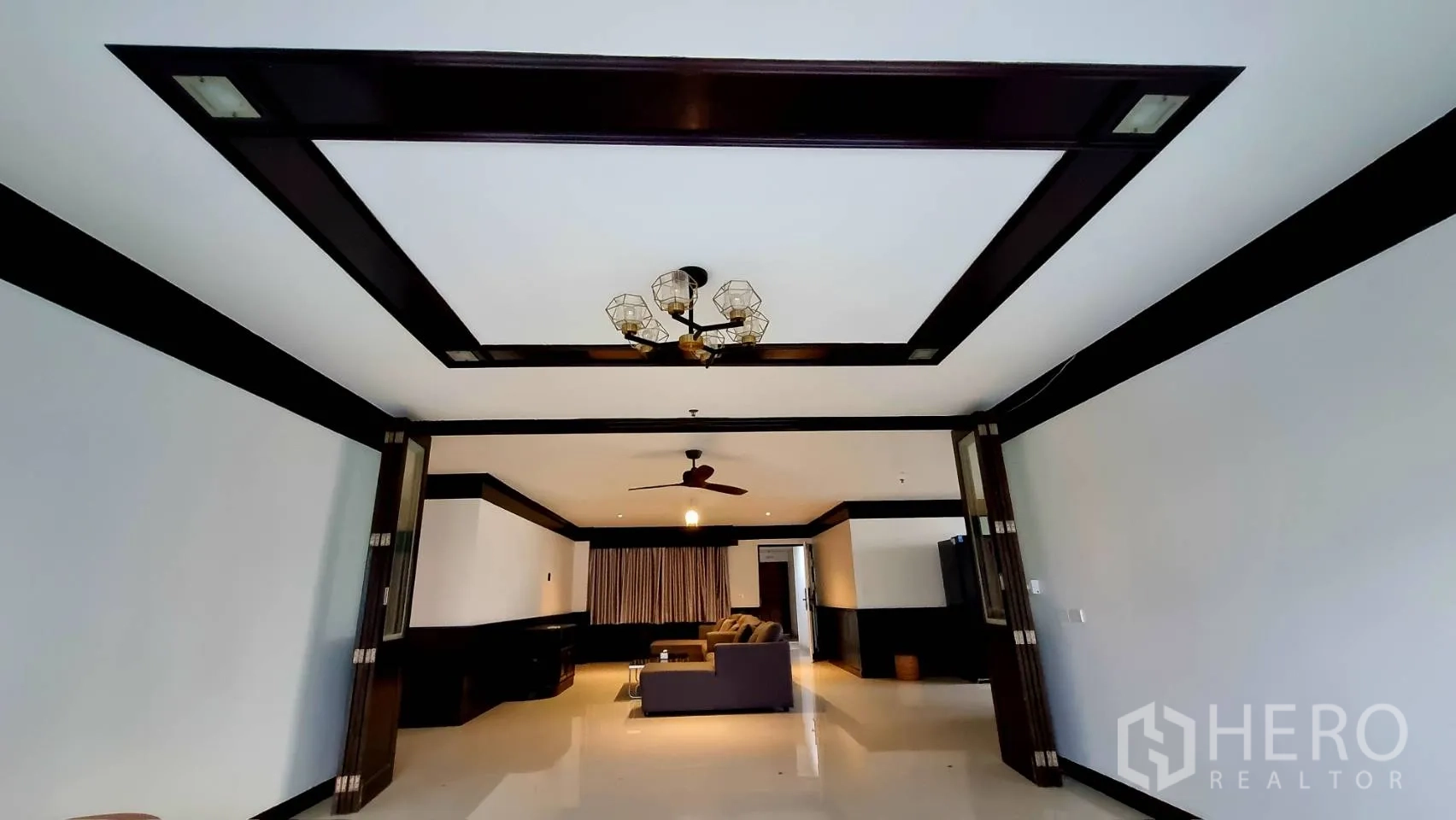 Condominium for rent in Watthana, Bangkok - Grand living space with decorative tray ceiling and chandelier.