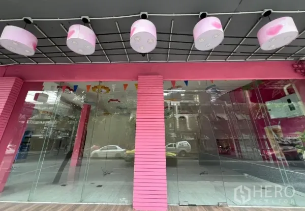 店屋 出租在Watthana, Bangkok - 粉色店屋外立面，临街整面落地玻璃与圆形吊灯。