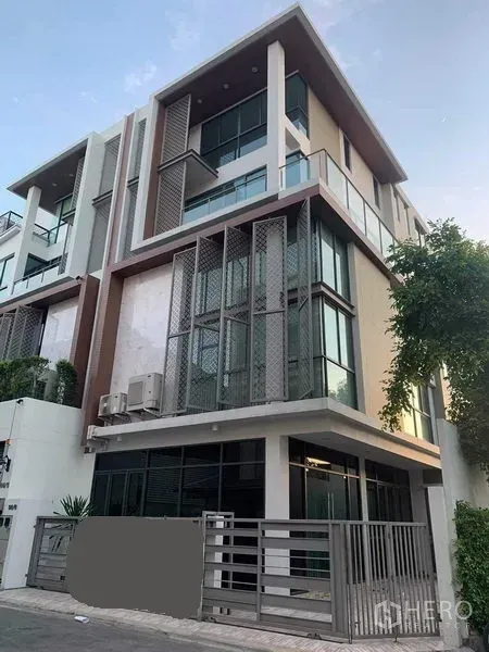 联排别墅 出租或出售在Yan Nawa, Bangkok - 转角视角的当代联排住宅，玻璃幕墙、阳台与安全大门。