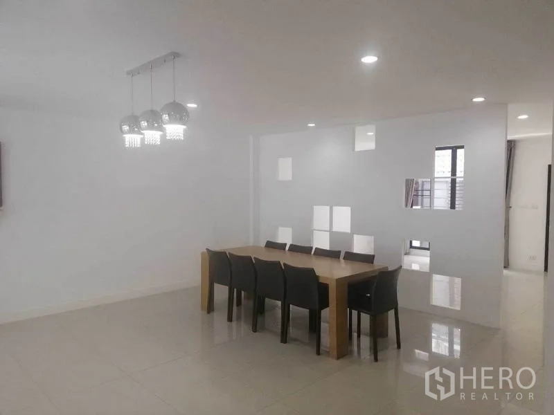 联排别墅 出租在Wang Thonglang, Bangkok - 大餐厅，八人长桌与现代吊灯。