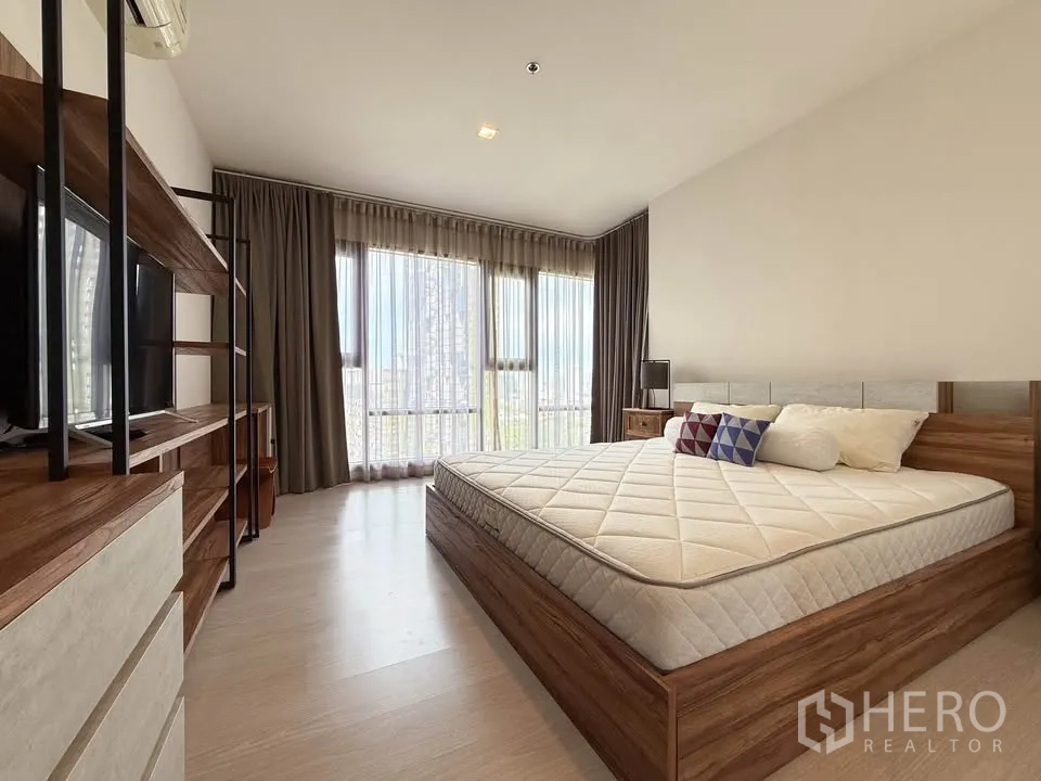 公寓 for rent in Khlong Toei, Bangkok - 通透明亮的房间，带大窗、床头柜与城市天际线。