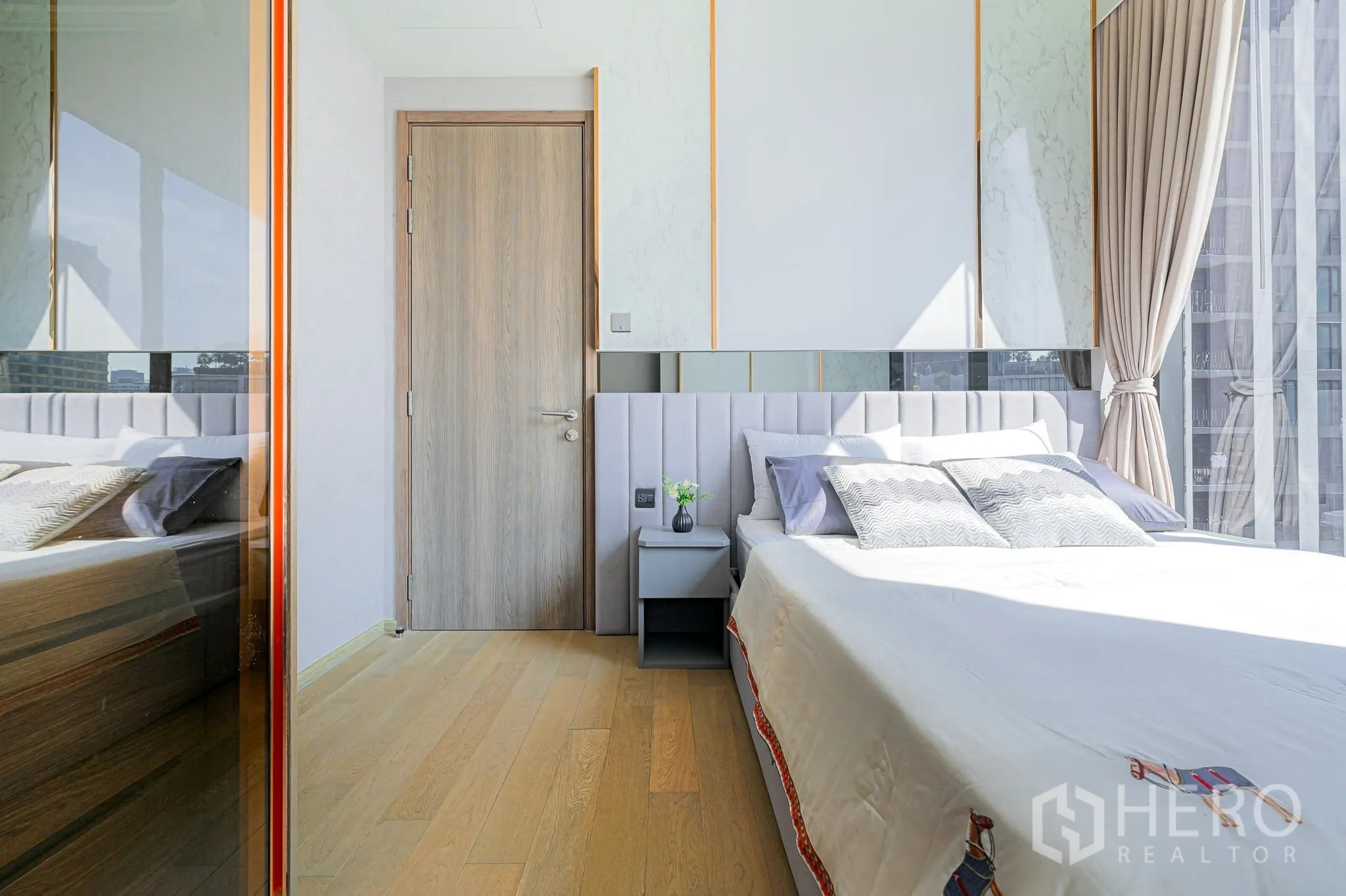คอนโด for rent in Watthana, Bangkok - ห้องนอนสว่าง พื้นไม้สีอ่อน หัวเตียงบุผ้า โต๊ะข้างเตียง และหน้าต่างสูงจรดเพดานมองเห็นวิวเมือง