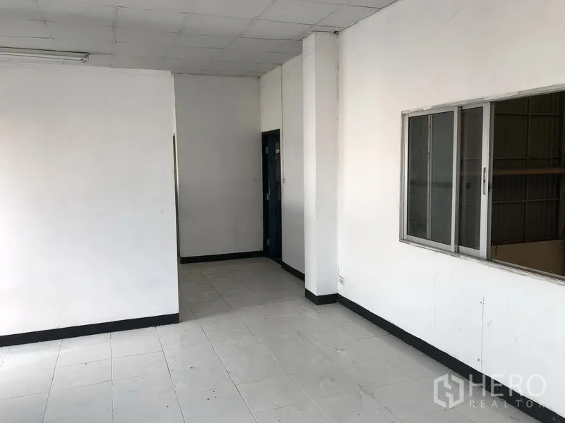 Factory for rent in Wang Noi, Phra Nakhon Si Ayutthaya - Clean tiled office room with white walls, ceiling lights, and a sliding window facing the warehouse.