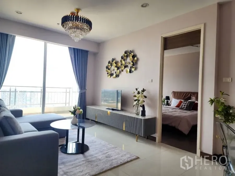 公寓 出租在Yan Nawa, Bangkok - 采光充足的客厅，沙发与电视柜，旁有通往卧室的门和落地窗