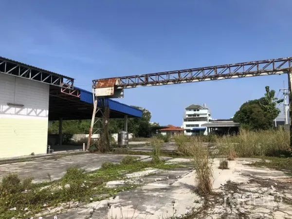 Warehouse for rent or sale in Lam Luk Ka, Pathum Thani - Large industrial yard with a steel gantry and covered loading bays.