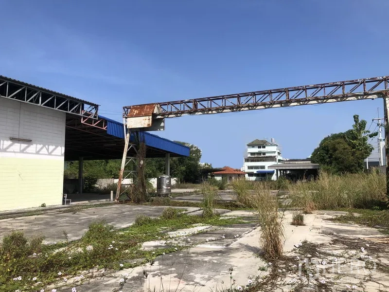 Warehouse for rent or sale in Lam Luk Ka, Pathum Thani - Large industrial yard with a steel gantry and covered loading bays.