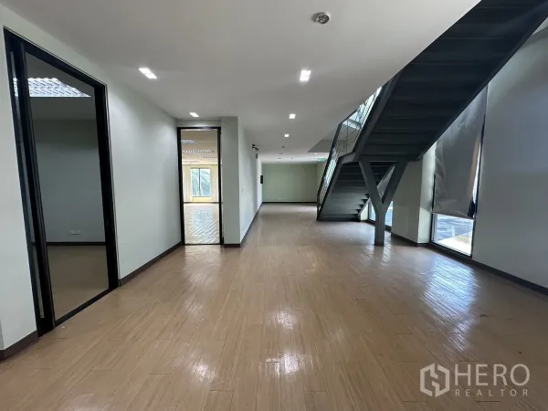 带办公室的家 出租在Prawet, Bangkok - 明亮大厅式办公区，带楼梯与落地窗采光。