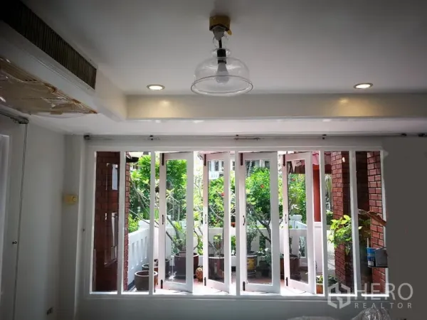 联排别墅 出租或出售在Watthana, Bangkok - 采光充足的房间，整面落地窗通向绿意阳台露台。